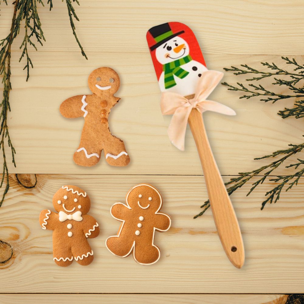 A colorful snowman patterned spatula is displayed with some gingerbread man cookies.