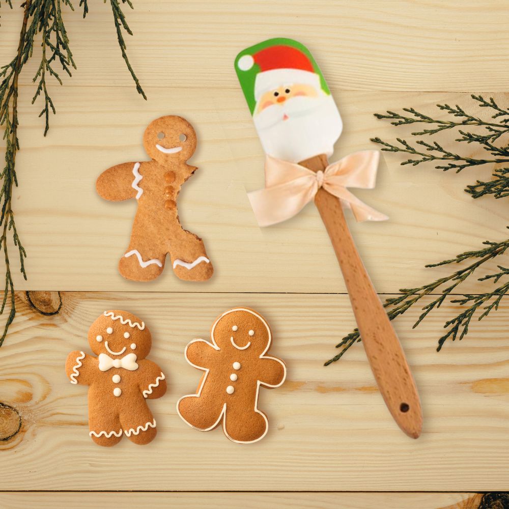 A colorful Santa patterned spatula is displayed with some gingerbread man cookies.