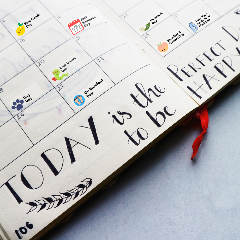 A planner is open to a page that says "Today is the Perfect Day to be happy" - some of the days have quirky holiday stickers on them.