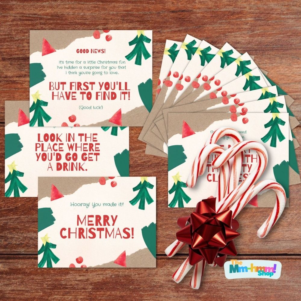 Pre-made treasure hunt clue cards featuring a hand-painted christmas tree design in classic Christmas colors are displayed with some decorative candy canes