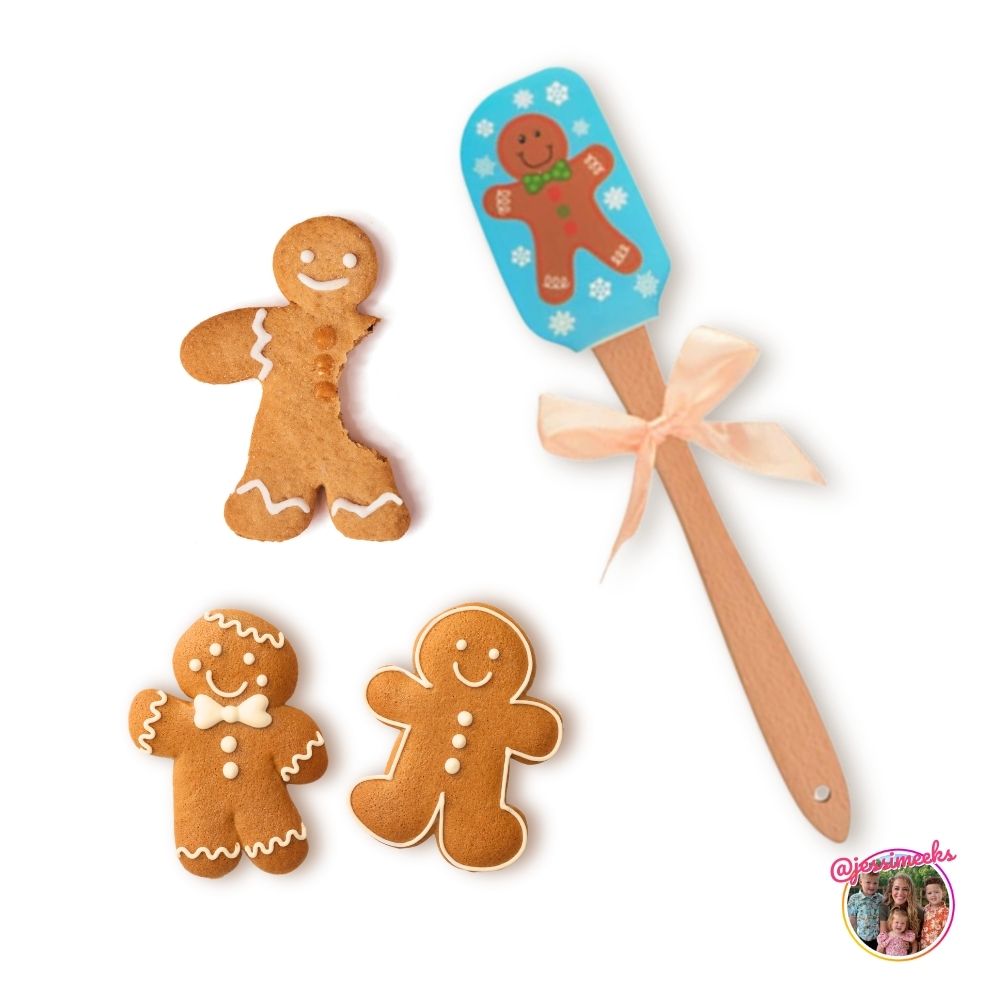 A colorful gingerbread man patterned spatula is displayed with some gingerbread man cookies.