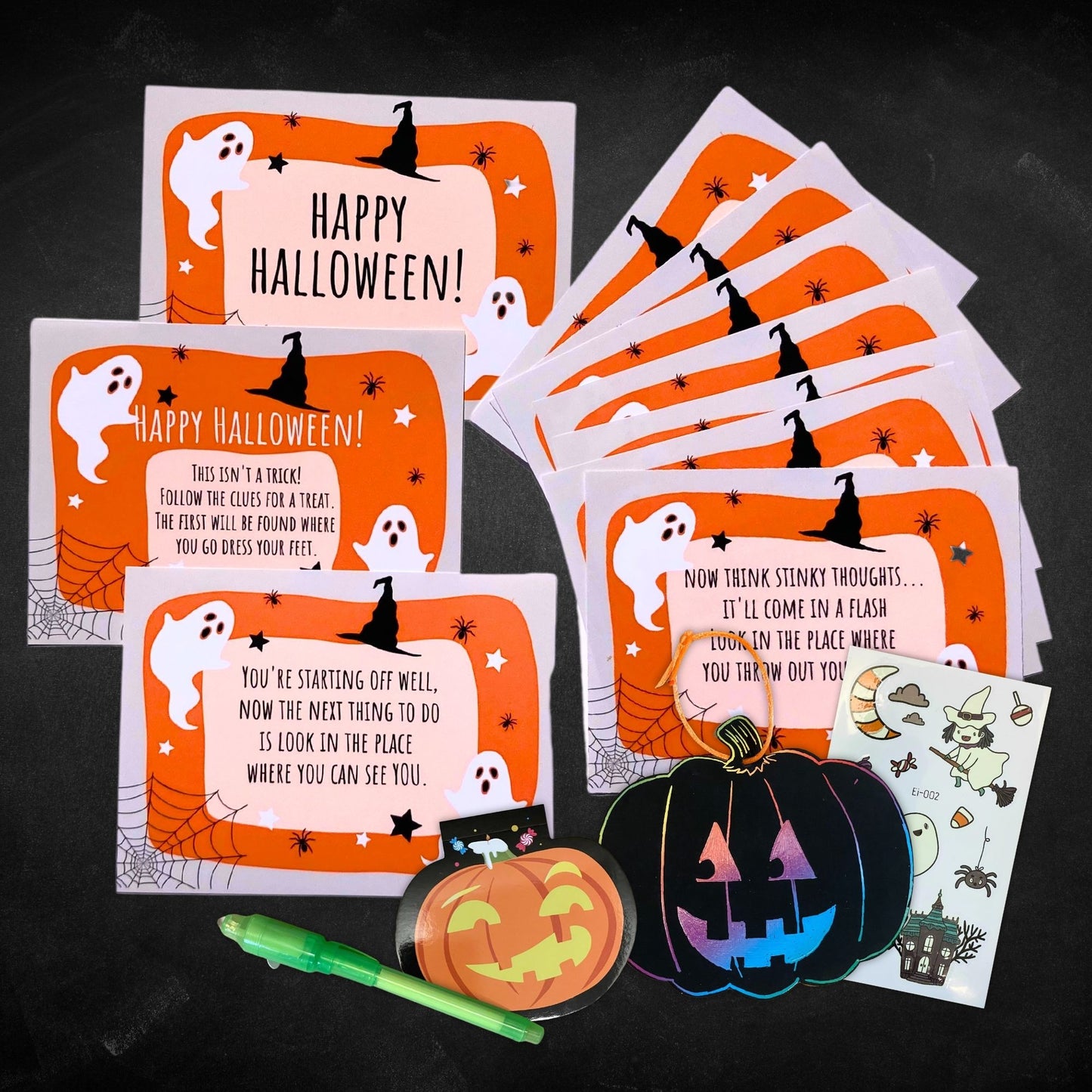 The cards to a halloween treasure hunt are displayed next to some prize pack items.