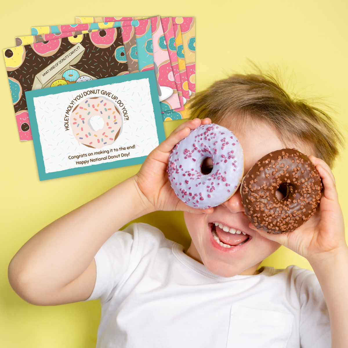 A boy puts donuts over his eyes and smiles next to the cards from his National Donut Day treasure hunt.