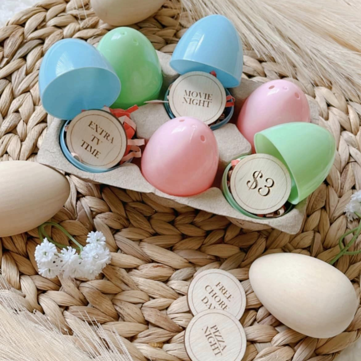 Wooden tokens displayed inside of easter eggs. Each token has a prize for redemption engraved on it. Examples include Extra TV Time, Movie Night, $3, Free Chore Day, Pizza Night