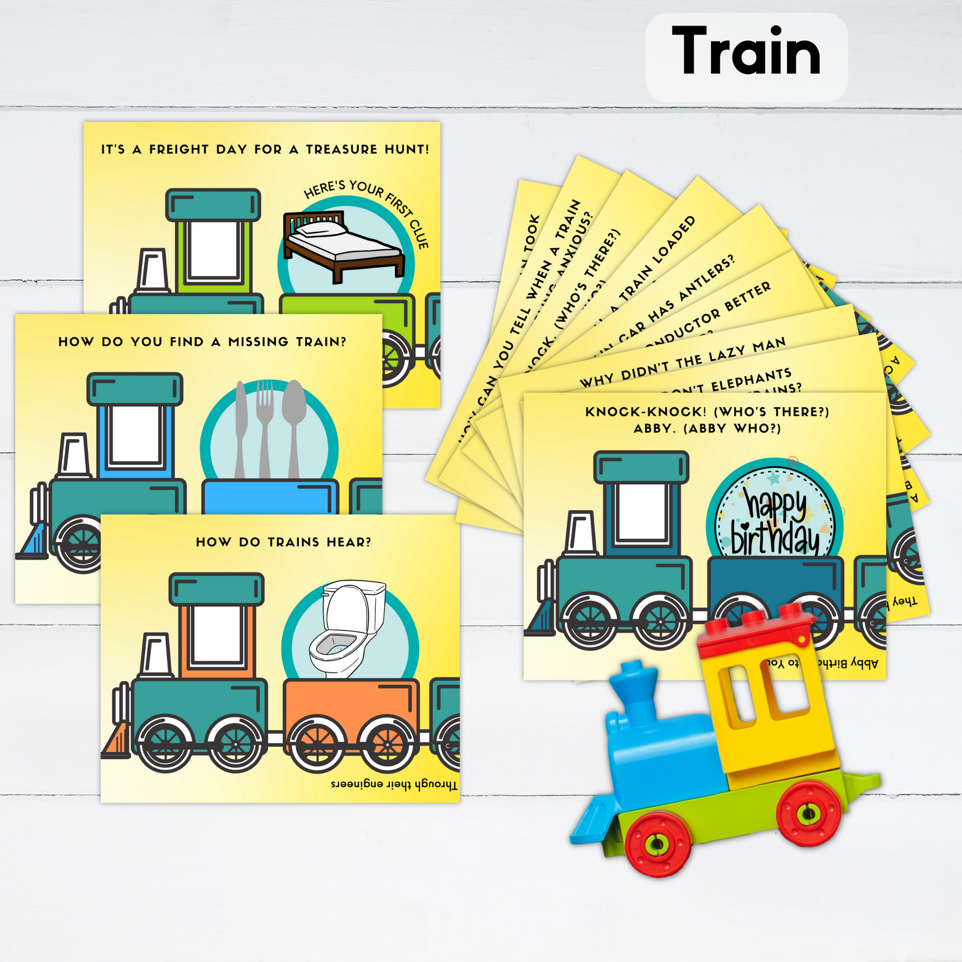 The cards for a train themed treasure hunt are displayed with a toy train.